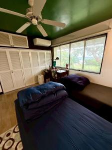 une chambre avec un lit et un ventilateur de plafond dans l'établissement 下田 OKIRAKU HOUSE, à Katsura