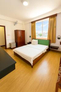 a bedroom with a large bed with a large window at Tâm Tín Hotel Hồ Chí Minh in Ho Chi Minh City