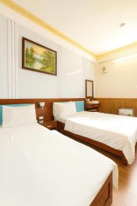 a hotel room with two beds and a picture on the wall at Tâm Tín Hotel Hồ Chí Minh in Ho Chi Minh City +44 photos