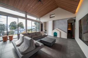 a living room with a couch and a fireplace at Doggo伊豆　愛犬と過ごす最高の時間の為に造られた貸切宿。温泉、プライベートドッグランで最高の一時を。 in Ito