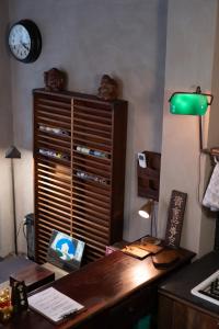 una oficina con un escritorio y un reloj en la pared en sishi hostel, en Tainan