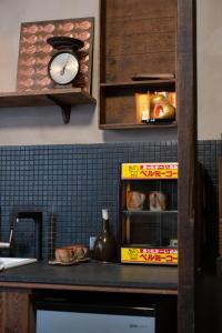 Un mostrador de cocina con un reloj y una caja de comida. en sishi hostel, en Tainan