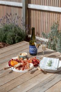 - une assiette de nourriture et une bouteille de vin sur une table dans l'établissement Magpie Sands - Ocean Views & Seaside Luxury - Steps to beach, à Aldinga Beach 33 autres photos