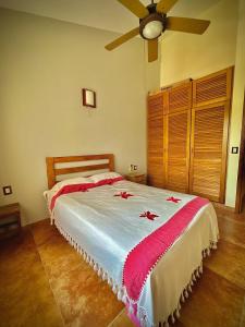 a bedroom with a bed with red flowers on it at Penthouse en Huatulco con alberca, balcón, 5 min playa in Santa Cruz Huatulco