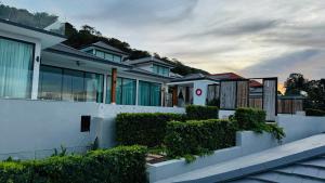 une maison avec une clôture blanche et des buissons dans l'établissement Sunterra villa, à Nathon Bay