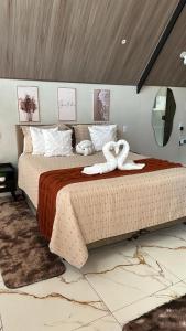 een slaapkamer met een groot bed met 2 zwanen erop bij Chalé do chamego in Alto Paraíso de Goiás