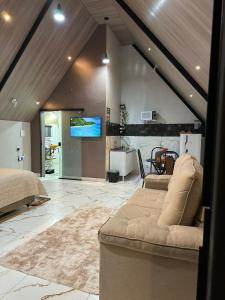 een slaapkamer met een bank en een tv in een kamer bij Chalé do chamego in Alto Paraíso de Goiás