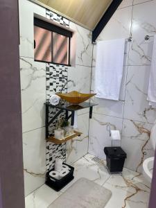 een badkamer met witte marmeren muren en een wastafel bij Chalé do chamego in Alto Paraíso de Goiás +12 foto's