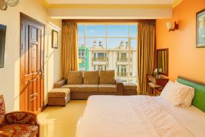 a bedroom with a bed and a couch and a window at Tâm Tín Hotel Hồ Chí Minh in Ho Chi Minh City