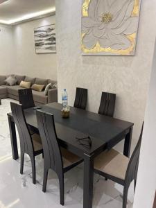 a black dining room table with chairs and a bottle of water at Perfect Studio Apartment La Cañada in Fès