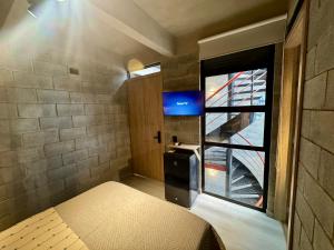 a small room with a bed and a window at Our Home Granada in Cali