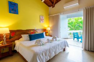 Un dormitorio con una cama con dos zapatos encima. en Hotel Mar Rey, en Tamarindo