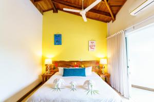 Un dormitorio con una cama blanca con una pared amarilla. en Hotel Mar Rey, en Tamarindo 93 fotos más