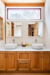 2 wastafels in een badkamer met een grote spiegel bij Riveret Karuizawa in Karuizawa +56 foto's