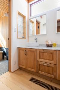 een badkamer met een wastafel en een spiegel bij Riveret Karuizawa in Karuizawa