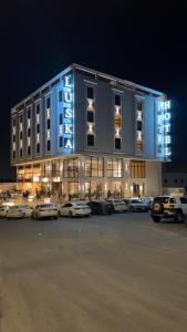 a large building with cars parked in a parking lot at فندق لوسكا in Abha +10 photos