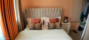 a bedroom with a bed with pillows at Embu Pacific Homes Two Bedroom in Embu +3 photos
