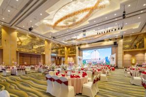 a banquet hall with tables and chairs and a projection screen at Cinese Hotel Dongguan Shijie in Dongguan +31 photos
