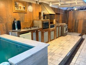 a kitchen with a swimming pool next to a kitchenasteryasteryasteryasteryasteryastery at Sweet Laguna Luxury House in Iguaba Grande