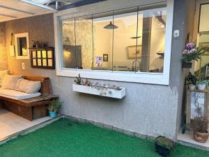 a patio with a couch and a window with green grass at Sweet Laguna Luxury House in Iguaba Grande +31 photos