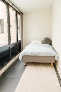 a bedroom with a bed and a large window at Newly renovated 3 BedRm, Spacious 80m sq, comtemporary Apartment in Central Trendy Oslo-Grunnerlokka in Oslo