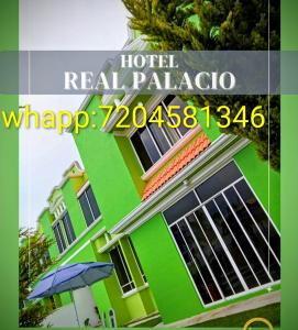 ビージャ・デル・カルボンにあるHotel real palacioの傘を前に置いた緑の建物