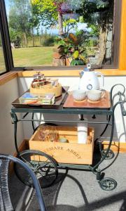 a table with a tea kettle on it in front of a window at Rose Ridge Retreat in Upper Moutere