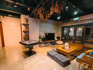 a living room with a table and a piano at Twenty Eight B&B in Xiaoliuqiu