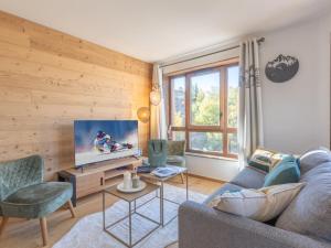 a living room with a couch and a tv at Appartement neuf avec balcon et accès direct aux pistes, 3 chambres, Alpe d'Huez - FR-1-645-94 in L'Alpe-d'Huez