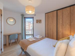 a bedroom with a large white bed and a desk at Appartement neuf avec balcon et accès direct aux pistes, 3 chambres, Alpe d'Huez - FR-1-645-94 in L'Alpe-d'Huez