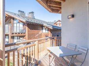 a balcony with a table and chairs on it at Appartement neuf avec balcon et accès direct aux pistes, 3 chambres, Alpe d'Huez - FR-1-645-94 in L'Alpe-d'Huez