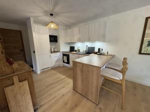 a kitchen with white cabinets and a wooden counter top at Appartement 3 Chambres avec Terrasse et Parking à Arâches-la-Frasse, Animaux Bienvenus - FR-1-836-41 in Les Carroz d'Araches +10 photos