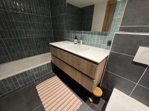 a bathroom with a sink and a bath tub at Appartement 3 Chambres avec Terrasse et Parking à Arâches-la-Frasse, Animaux Bienvenus - FR-1-836-41 in Les Carroz d'Araches