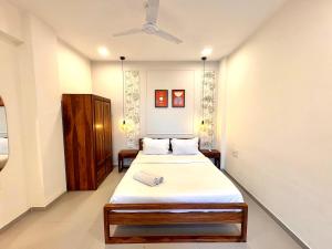 a bedroom with two beds and a ceiling fan at Relaxing 2BHK with Mangrove View - Family-Friendly, Pool - Candolim Beach in Candolim +34 photos