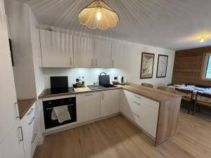 a kitchen with white cabinets and a chandelier at Appartement 3 Chambres avec Terrasse et Parking à Arâches-la-Frasse, Animaux Bienvenus - FR-1-836-41 in Les Carroz d'Araches