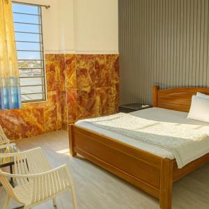 a bedroom with a bed and a chair and a window at Hải Quỳnh Hotel in Ho Chi Minh City