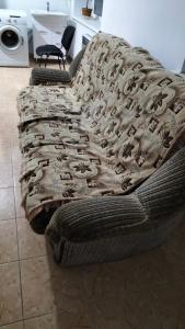 un sofá con una manta en una habitación en Хостел Москва, en Aktobe 4 fotos más