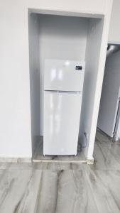 a white refrigerator in a room with a wall at Las Palomas Residences in San Juan