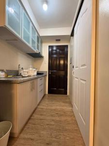 a kitchen with a hallway leading to a door at Urban Oasis Cozy Studio at Berkeley Suites South Forbes Nuvali in Silang
