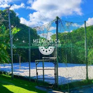 a sign on a fence in front of a tennis court at Bangalô Melancia C4 in Maceió