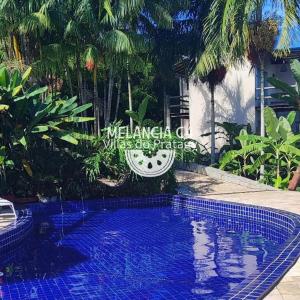 a swimming pool in a yard with trees at Bangalô Melancia C4 in Maceió