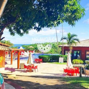 a resort with tables and chairs and a pool at Bangalô Melancia C4 in Maceió