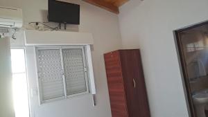 a room with a window and a tv on the wall at Habitación en 25 in Veinticinco de Mayo