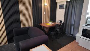 a living room with a chair and a table at Bay Lodge Motel in Tauranga