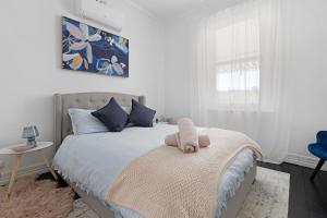 a bedroom with a bed with a stuffed animal on it at Courthouse - Family Retreat Near Bendigo CBD in Bendigo