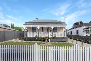 a white picket fence in front of a house at Courthouse - Family Retreat Near Bendigo CBD in Bendigo