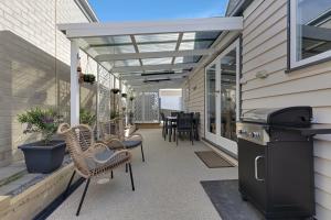 a screened porch with chairs and a grill on a house at Courthouse - Family Retreat Near Bendigo CBD in Bendigo +2 photos