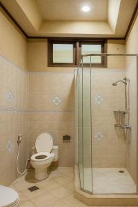 にあるAthaya Beachside Villaのトイレとガラスのシャワー付きのバスルーム +11枚の写真