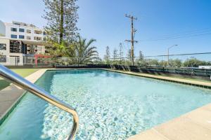a swimming pool with blue water in a building at Shara Seaside Oasis - Alex Beach 3BD Apartment in Alexandra Headland