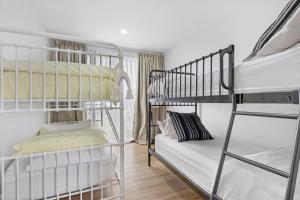 una habitación con dos literas y un sofá en California 'Luxe Boho' with Pool, en Echuca